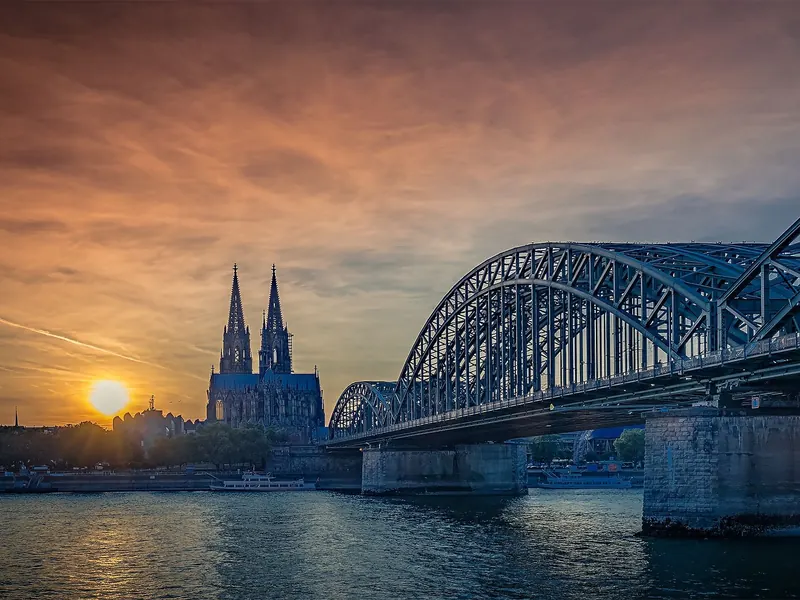 Köln: Sonnenuntergang hinter dem Dom, davor die Hohenzollernbrücke über dem Rhein